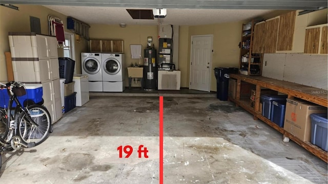 garage featuring electric water heater, washer and clothes dryer, a sink, a garage door opener, and a workshop area