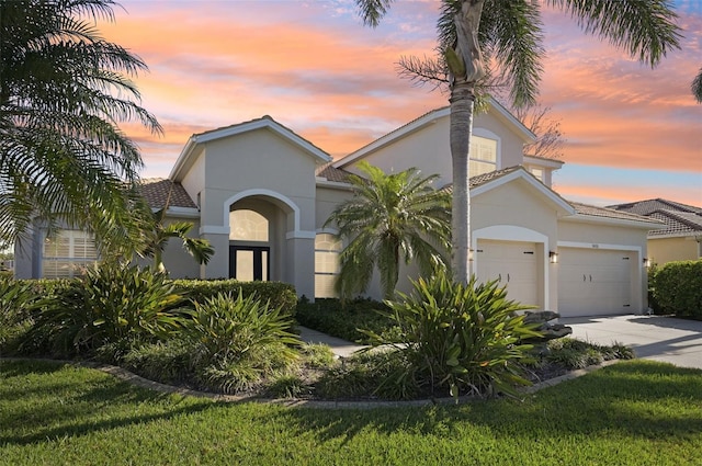 1655 Pinyon Pine Dr, Sarasota, FL 34240 - mediterranean / spanish-style home with stucco siding, a garage, and concrete driveway