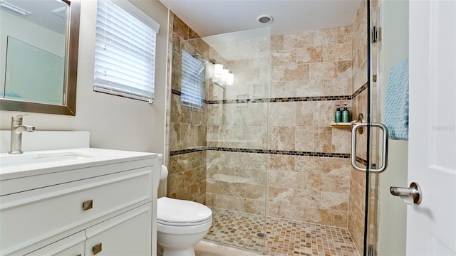 full bathroom with a shower stall, toilet, and vanity