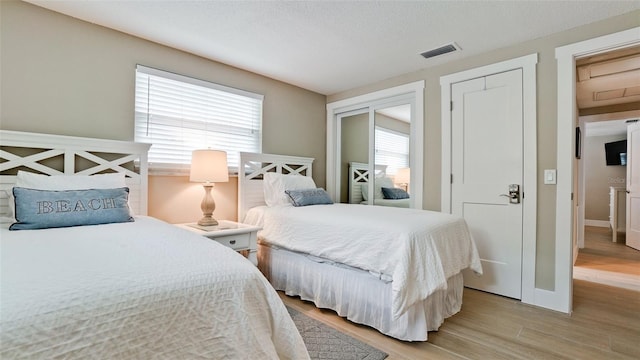 bedroom with visible vents, baseboards, and light wood-style floors
