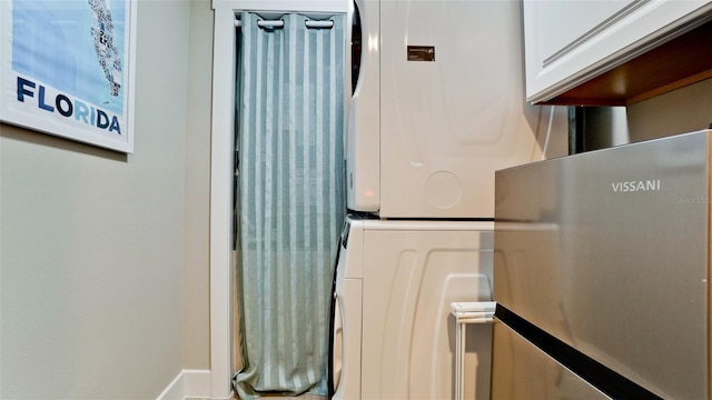 room details featuring stacked washer and clothes dryer and baseboards