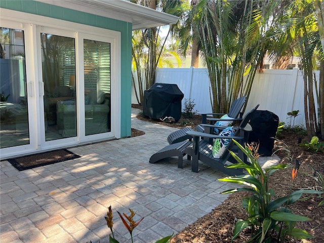 view of patio with area for grilling and fence