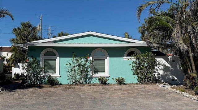 view of front of house with fence and stucco siding