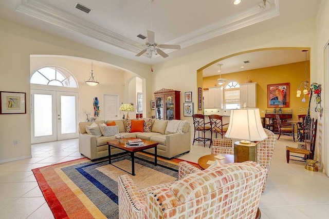 7762 US Open Loop, Lakewood Ranch, FL 34202 - living room with arched walkways, ornamental molding, light tile patterned floors, a tray ceiling, and a ceiling fan