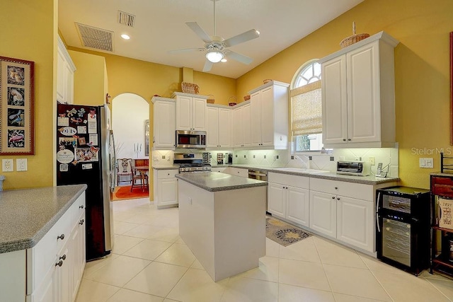 7762 US Open Loop, Lakewood Ranch, FL 34202 - kitchen featuring appliances with stainless steel finishes, ceiling fan, a sink, arched walkways, and white cabinets