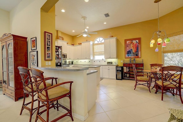 7762 US Open Loop, Lakewood Ranch, FL 34202 - kitchen with ceiling fan, light tile patterned floors, a kitchen bar, white cabinetry, and recessed lighting