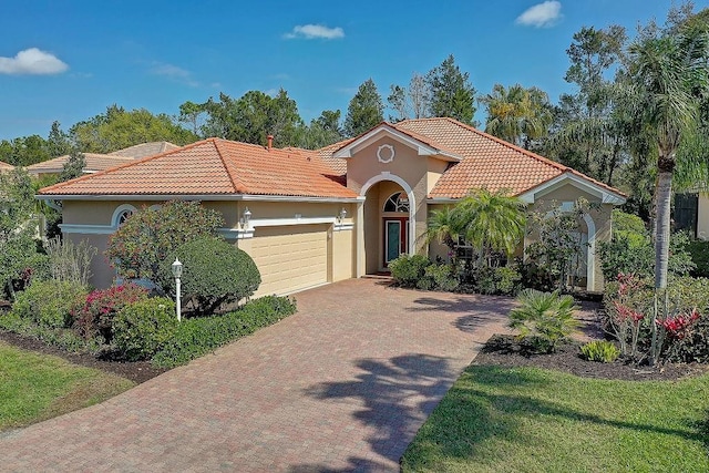 7762 US Open Loop, Lakewood Ranch, FL 34202 - mediterranean / spanish home featuring a tiled roof, decorative driveway, a garage, and stucco siding