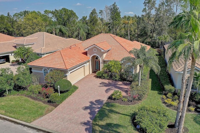7762 US Open Loop, Lakewood Ranch, FL 34202 - mediterranean / spanish home with a tiled roof, an attached garage, stucco siding, decorative driveway, and a front yard