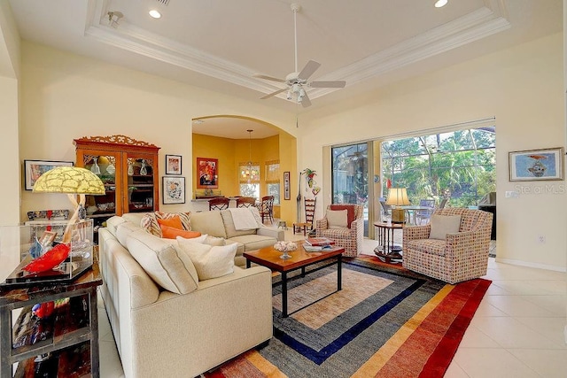7762 US Open Loop, Lakewood Ranch, FL 34202 - living room with arched walkways, a ceiling fan, light tile patterned floors, a raised ceiling, and crown molding