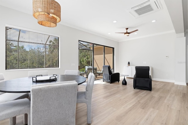 dining area with baseboards, ornamental molding, visible vents, and light wood-style floors