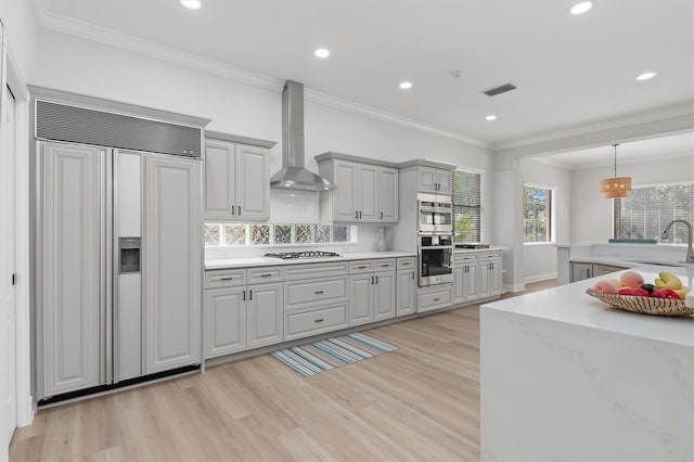 kitchen featuring stainless steel double oven, paneled built in refrigerator, gas stovetop, visible vents, and wall chimney range hood