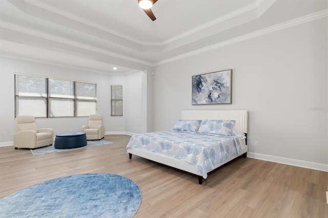 bedroom with a ceiling fan, baseboards, a raised ceiling, and wood finished floors