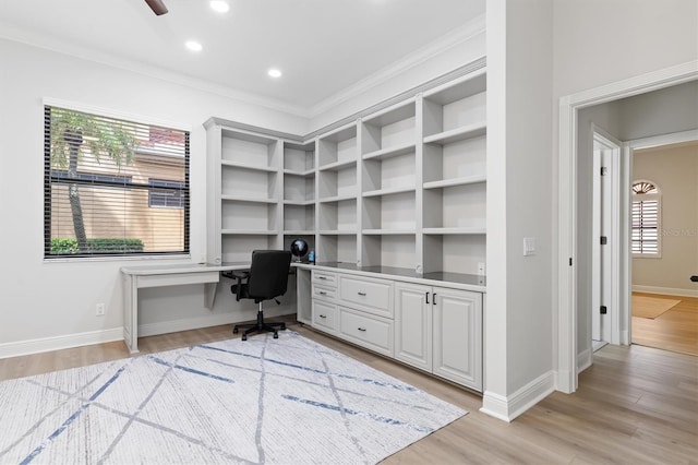 office featuring baseboards, crown molding, light wood-style floors, built in desk, and recessed lighting