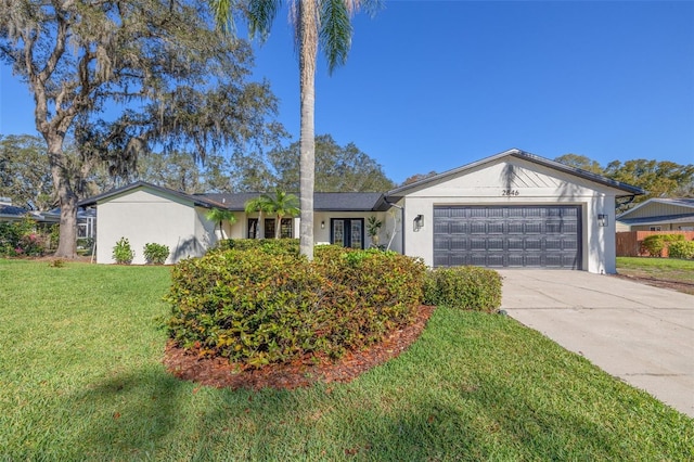 ranch-style house featuring a garage, concrete driveway, a front yard, and stucco siding