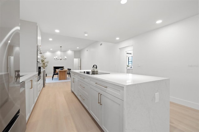 kitchen featuring white cabinets, light wood-style flooring, stainless steel appliances, and recessed lighting