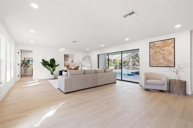 living area with light wood-type flooring, visible vents, and recessed lighting