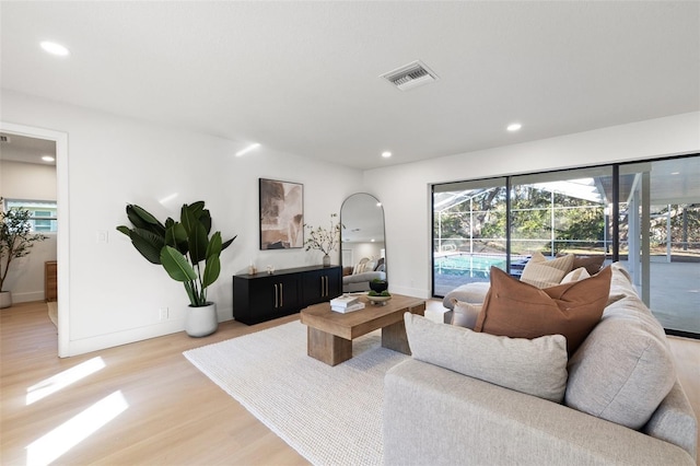 living area with recessed lighting, visible vents, light wood-style flooring, a sunroom, and baseboards