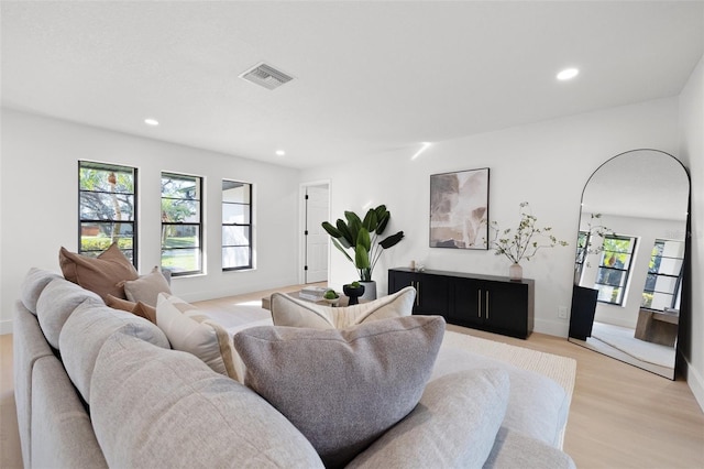 living room with light wood-style floors, plenty of natural light, visible vents, and recessed lighting