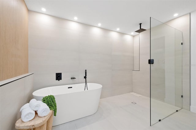 full bath featuring recessed lighting, a soaking tub, tile walls, and walk in shower