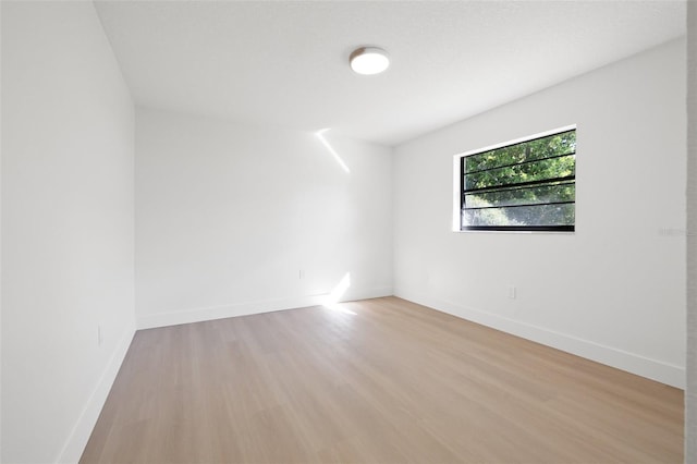 empty room featuring light wood-style flooring and baseboards