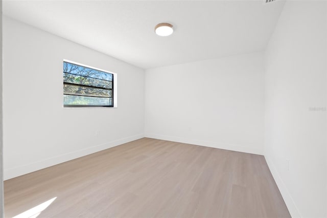 unfurnished room with baseboards and wood finished floors