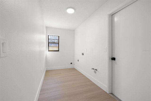 laundry area with light wood-style flooring, hookup for an electric dryer, gas dryer hookup, laundry area, and baseboards