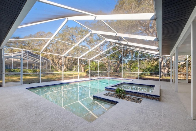 view of pool with a pool with connected hot tub, a patio area, and a lanai