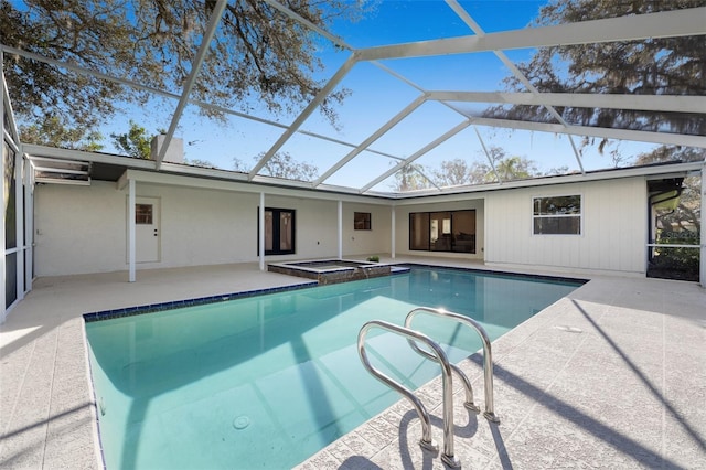 pool featuring a lanai, a patio, and an in ground hot tub