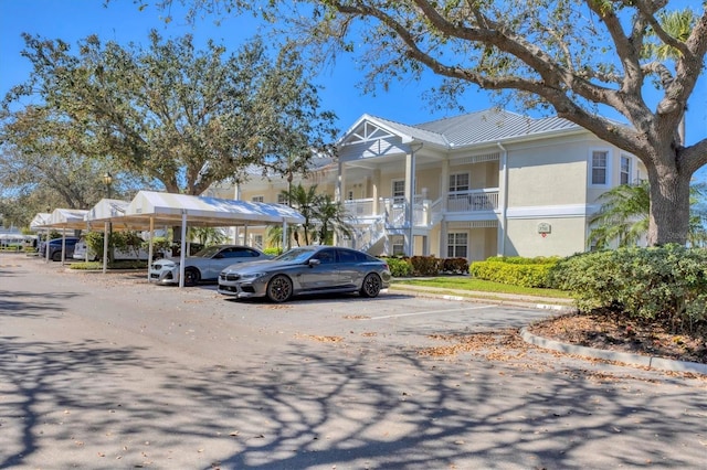 view of building exterior featuring covered and uncovered parking