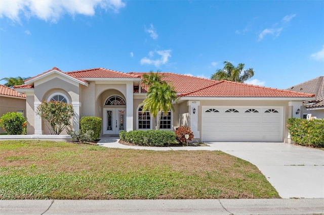 4173 Hearthstone Dr, Sarasota, FL 34238 - mediterranean / spanish-style home featuring a front yard, stucco siding, a tiled roof, and a garage