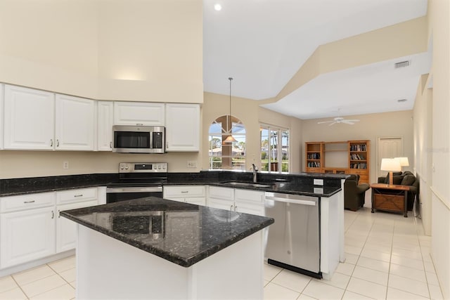 4173 Hearthstone Dr, Sarasota, FL 34238 - kitchen featuring stainless steel appliances, a peninsula, high vaulted ceiling, light tile patterned floors, and white cabinets