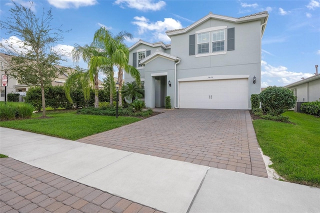 view of front of property with a garage, a front lawn, decorative driveway, and stucco siding