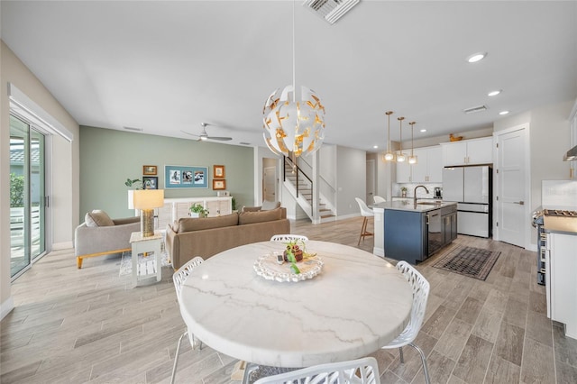 dining space with stairway, light wood-style flooring, visible vents, and recessed lighting