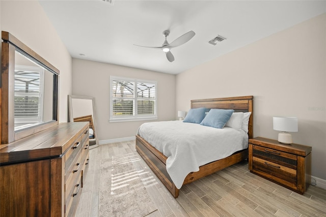 bedroom with light wood-style flooring, visible vents, baseboards, and ceiling fan