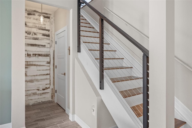 stairway featuring baseboards and wood tiled floor