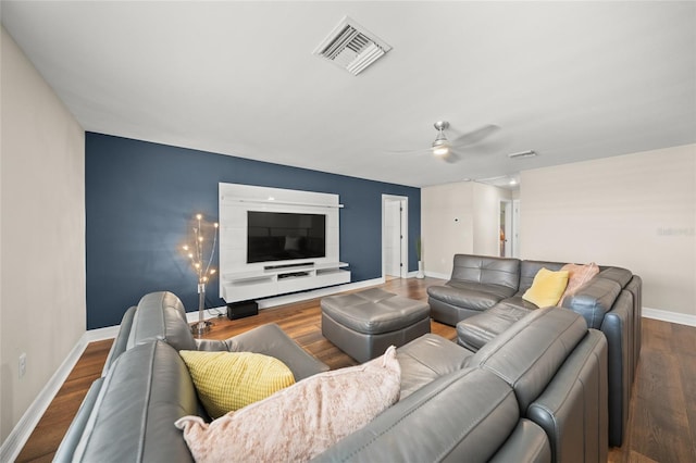 living area featuring visible vents, ceiling fan, baseboards, and wood finished floors