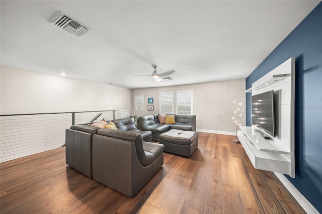 living room with wood-type flooring, visible vents, ceiling fan, and baseboards