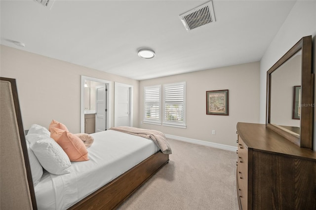 bedroom featuring light carpet, baseboards, visible vents, and ensuite bathroom