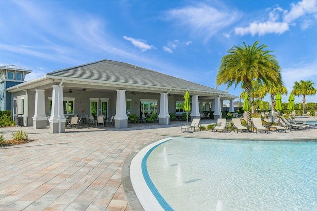 community pool with a ceiling fan and a patio