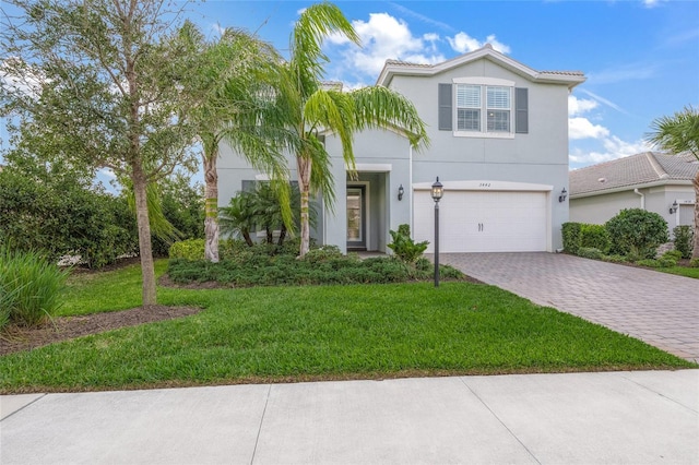 view of front of home featuring a front lawn, decorative driveway, an attached garage, and stucco siding