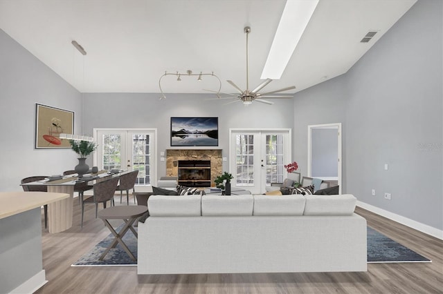 living room with high vaulted ceiling, french doors, visible vents, and wood finished floors