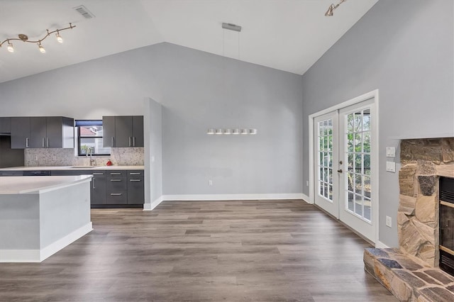 kitchen with a fireplace, a sink, wood finished floors, light countertops, and french doors