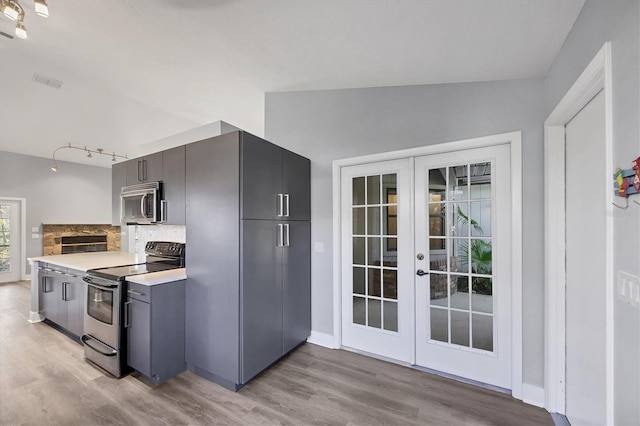 kitchen featuring french doors, appliances with stainless steel finishes, light countertops, and light wood-style flooring