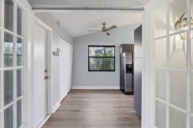 foyer with vaulted ceiling, wood finished floors, a ceiling fan, and baseboards