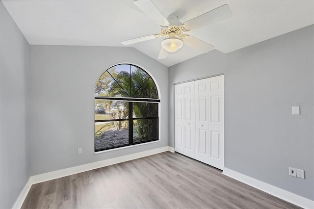 unfurnished bedroom featuring a closet, baseboards, and wood finished floors