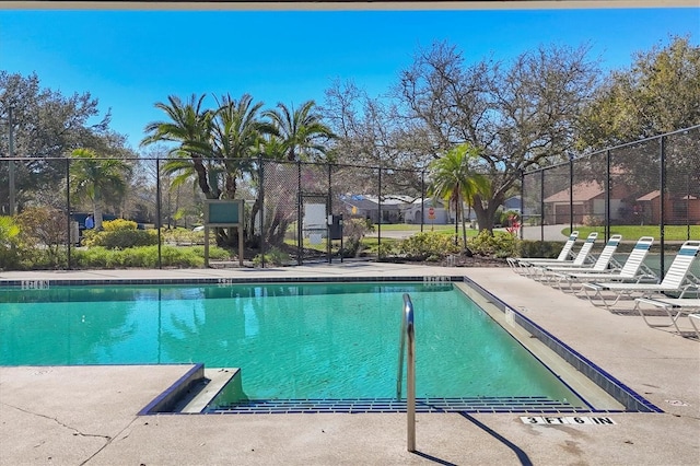 community pool with fence and a patio