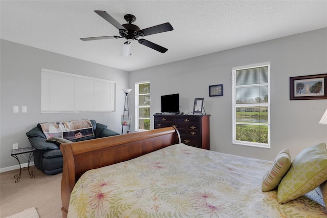 bedroom with a textured ceiling, carpet floors, a ceiling fan, and baseboards