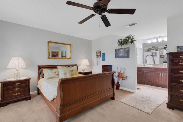 bedroom featuring visible vents, connected bathroom, light carpet, and baseboards