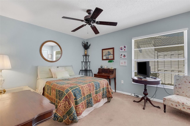 carpeted bedroom featuring ceiling fan, a textured ceiling, and baseboards