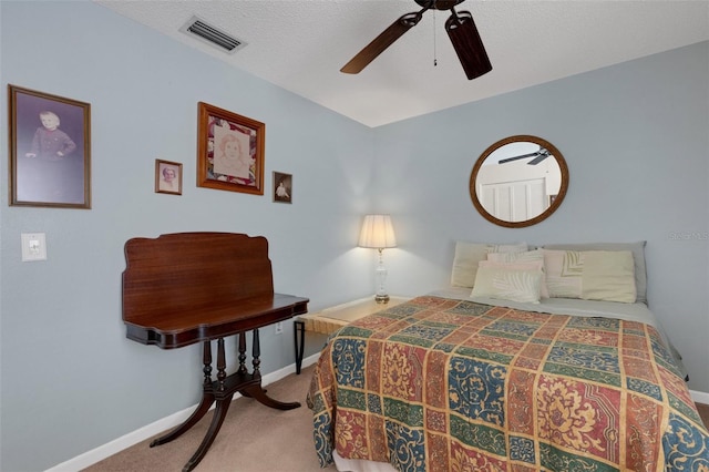 carpeted bedroom with visible vents, ceiling fan, a textured ceiling, and baseboards